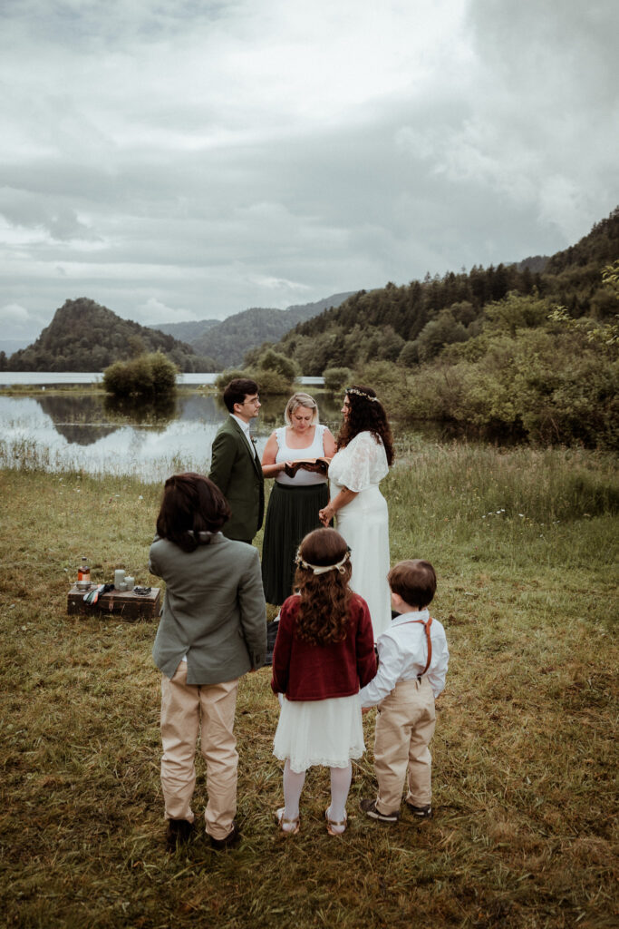 Les mariés entourés de leur enfant et de l'officiante de cérémonie laïque le jour de leur renouvellement de voeux de mariage à l'occasion de leur anniversaire de mariage