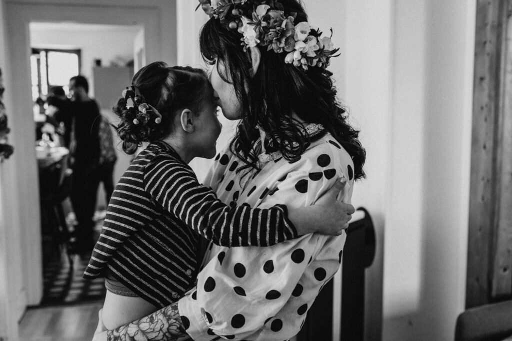 photo en noir et blanc de la future mariée avec sa fille dans les bras avant d'enfiler sa robe de mariée en Alsace près de Colmar.