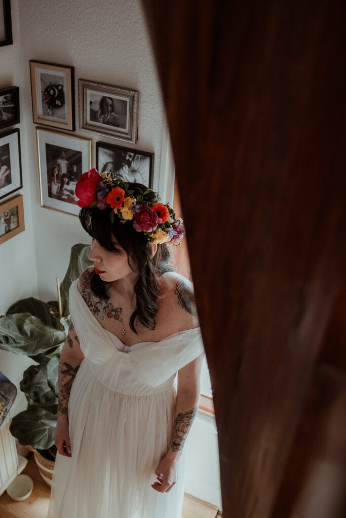 Photo de la mariée avec sa couronne de fleurs et sa robe de mariée chez elle avant de partir à la Mairie en Alsace près de Colmar