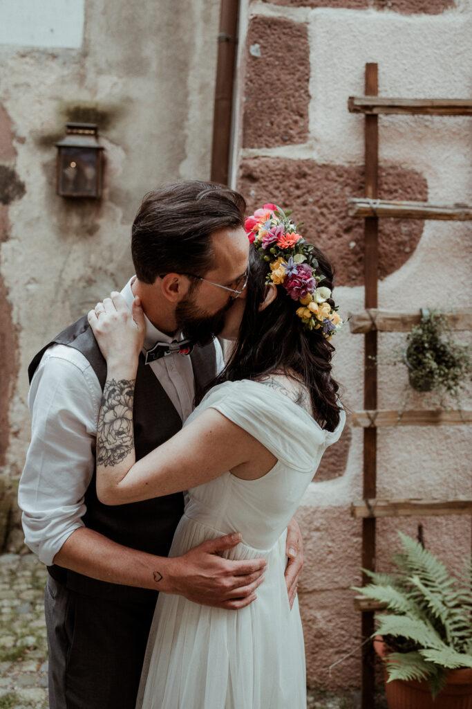 Le marié prend la mariée dans ses bras lors de la séance photo couple de leur mariage dans les rues de Riquewihr en Alsace près de Colmar