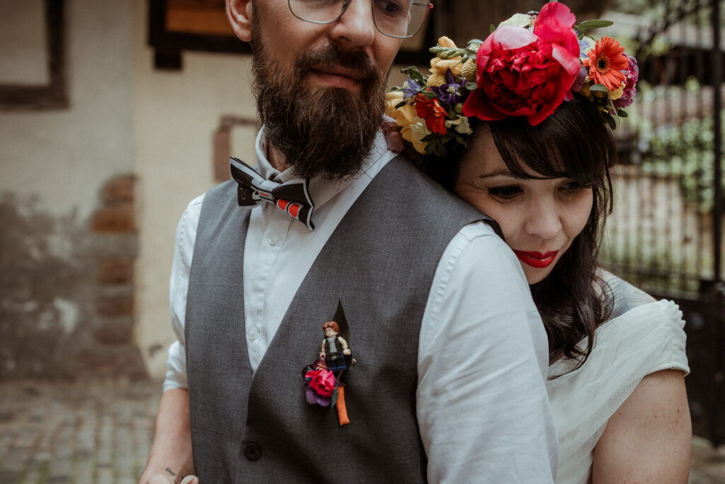 Photo des mariés et de la couronne de la mariée ainsi que la boutonnière fleurie avec un lego