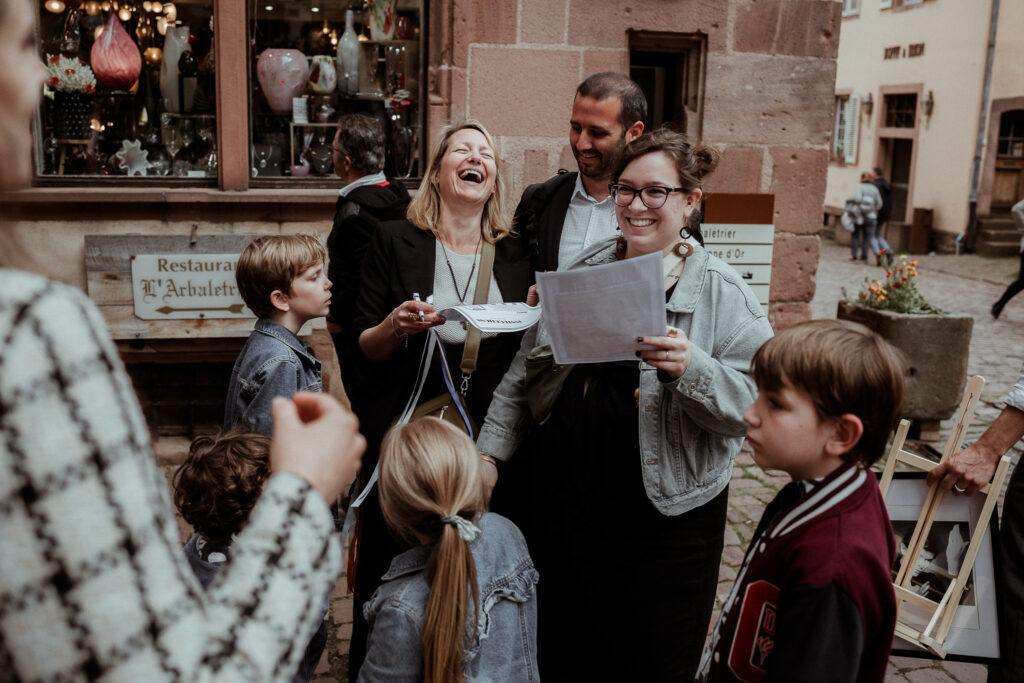 Les invités du mariage font un escape game dans les rues de Riquewihr en Alsace près de Colmar avant le vin d'honneur