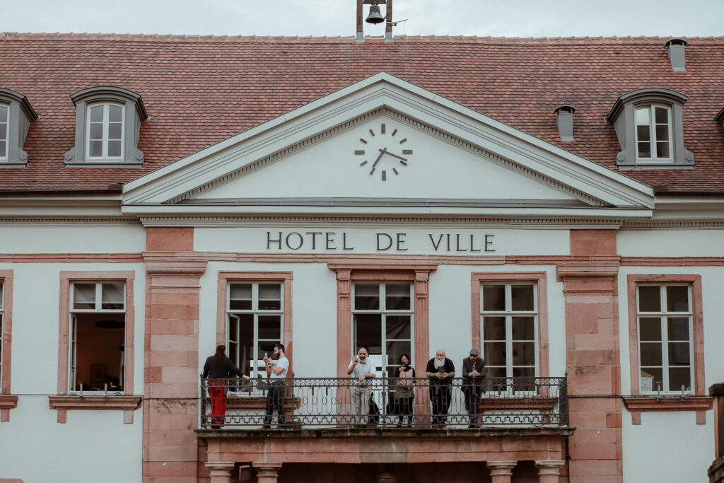 Les invités au balcon de la mairie attendent les mariés suite à l'escarpe game dans les rues de Riquewihr en Alsace entre Colmar et Strasbourg